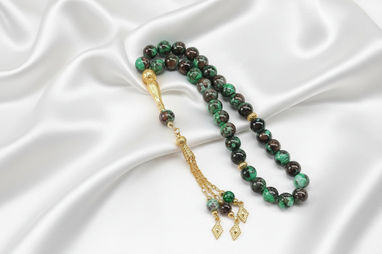 Tasbih de 33 perles de 10mm aux motifs marbrés vert émeraude et marron foncé, avec séparateurs dorés ciselés et pompon doré luxueux à chaînettes.