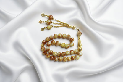 Tasbih de 33 perles de 10mm noires lisses et brillantes, avec séparateurs en argent ciselé et pompon argenté à trois chaînettes.